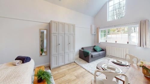 a living room with a table and a couch at Hidden Jewel Retreat in Budleigh Salterton