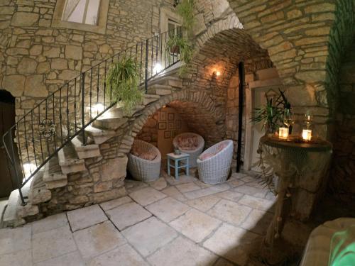 a stone staircase with wicker chairs and a stair case at Stone House Hedonia in Blato