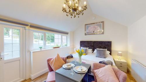 a bedroom with a bed and a couch and a table at Hidden Gem Retreat in Budleigh Salterton