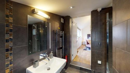a bathroom with a sink and a shower and a mirror at Hidden Gem Retreat in Budleigh Salterton