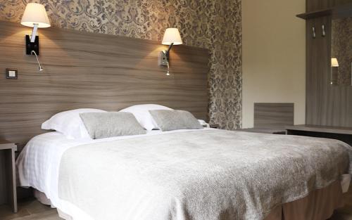 
A bed or beds in a room at Logis Grand Hôtel Bourbon-Lancy
