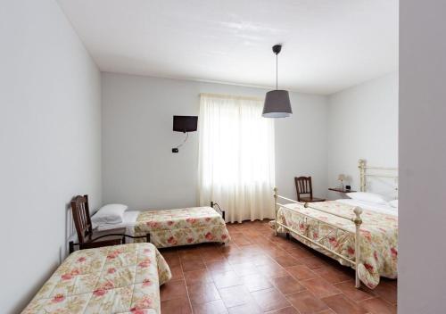 a bedroom with two beds and a table and a window at Agriturismo Il Sentiero degli Ulivi - Irpinia in Venticano