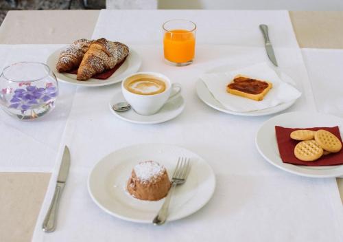 a table with plates of breakfast foods and a cup of coffee at Agriturismo Il Sentiero degli Ulivi - Irpinia in Venticano