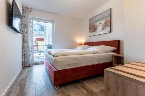 - une chambre avec un grand lit et une fenêtre dans l'établissement App 20, Strandresidenz Dünenperle, à Kühlungsborn