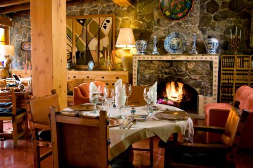 a dining room with a table and a fireplace at Hotel Rancho San Cayetano in Zitácuaro