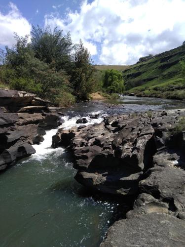 a river with rocks in the middle of a river at Sheeprun Farmstay in Maclear