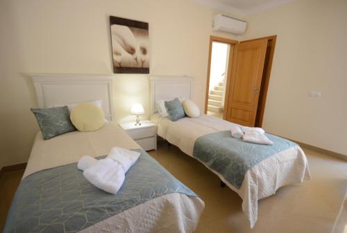 a bedroom with two beds with towels on them at Casa Da Torre Espetacular V4 Com Piscina in Portimão