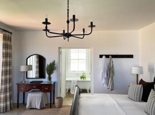 a bedroom with a bed and a table and a mirror at Penhill Farm West Grange in Nuy
