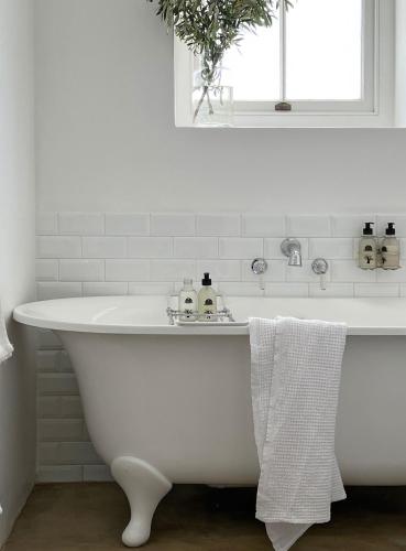 a white bath tub in a bathroom with a window at Penhill Farm Fruit Barn in Nuy