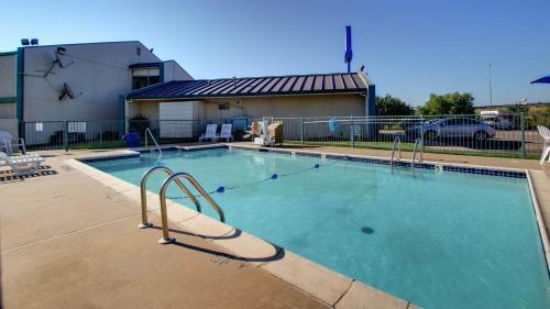 a large swimming pool with a playground in a yard at Baymont Inn & Suites Shawnee in Shawnee