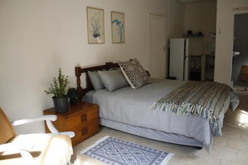 a bedroom with a bed and a chair in it at Sheeprun Farmstay in Maclear