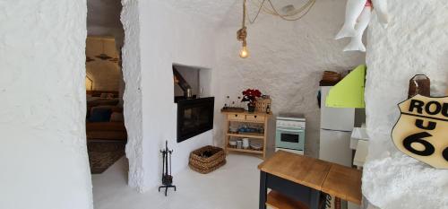 a small white room with a table and a kitchen at Los Andenes Cave in La Coruña