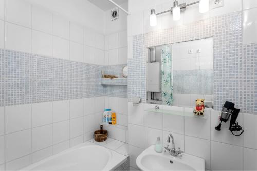 Bartakovics Apartman في إغير: حمام أبيض مع حوض ومرآة