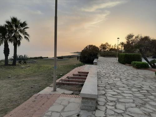 a stone walkway with a palm tree and a street light at Casa Romano - Marina di Modica in Marina di Modica