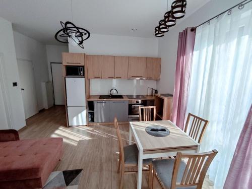 a living room with a table and a kitchen at Apartament Białowieski in Hajnówka
