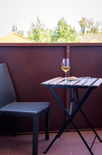 a table with a glass of wine and a chair at Hotel Römerhof in Tulln