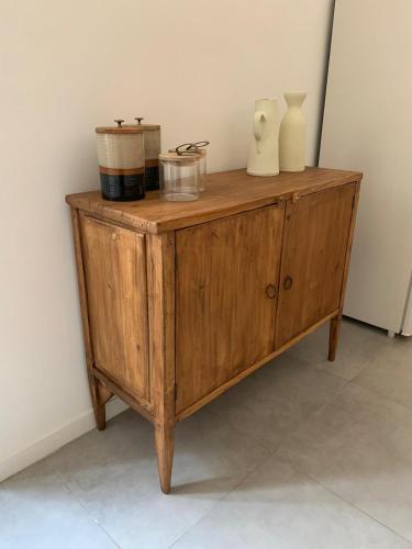a wooden cabinet with vases and containers on it at CASA ARCO BIANCO in Giovinazzo