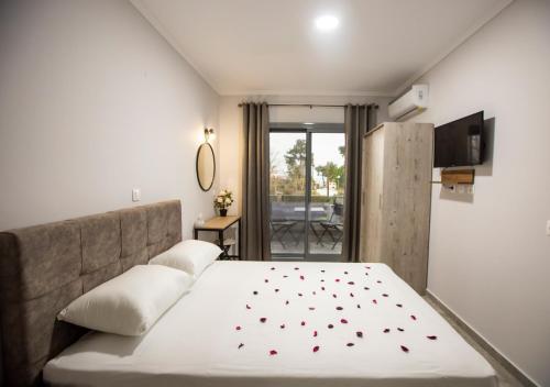 een slaapkamer met een bed met rode harten erop bij Artemida Suites in Hanioti