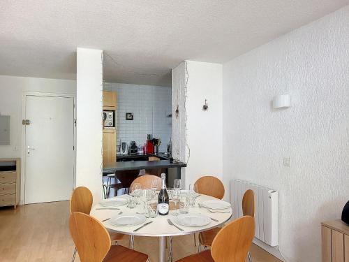 une salle à manger avec une table et des chaises blanches dans l'établissement APPARTEMENT DUPLEX SPACIEUX -SAINT JEAN D'AULPS STATION-PROCHE MORZINE - 6-8 pers-RELAIS D7, à Saint-Jean-dʼAulps