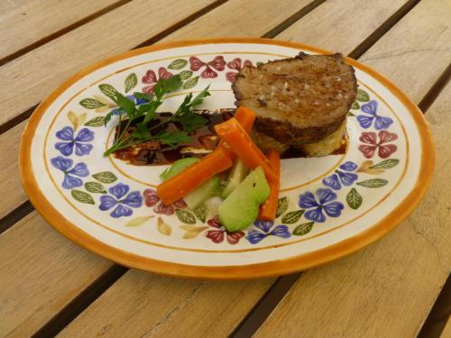a plate of food with meat and vegetables on a table at Hotel Rancho San Cayetano in Zitácuaro