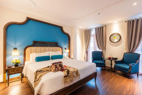 1 dormitorio con 1 cama grande y 2 sillas azules en Hanoi Tirant Hotel, en Hanói