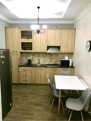 kuchnia z drewnianymi szafkami, stołem i krzesłami w obiekcie David APT 1A w mieście Batumi