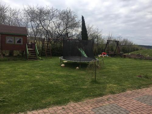 a playground with a trampoline in the grass at Zakątek Mikołajewo 14 in Mikolajewo