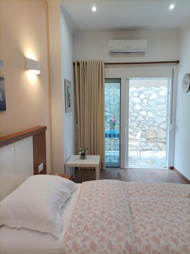 een slaapkamer met een bed en een deur naar een patio bij sofia's cozy rooms in Himare