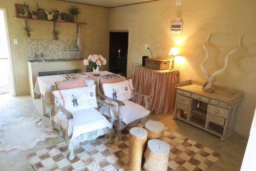 una stanza con tavolo e sedie e un tavolo con fiori di Zeekoegat Country House BñB a Vosburg