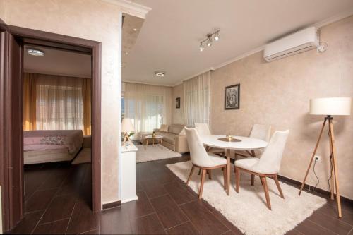 a bedroom and a living room with a table and chairs at ENA Apartment in Kotor