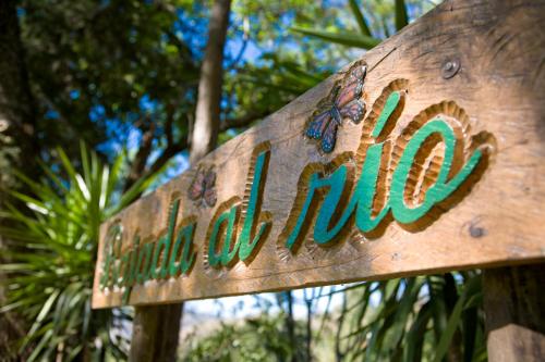a wooden sign for a jungle museum with trees in the background at Hotel Rancho San Cayetano in Zitácuaro
