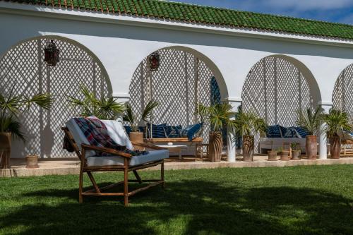 a chair sitting in the grass in front of a building at Maison Marine in Oualidia