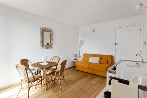 uma sala de estar com uma mesa e cadeiras e um sofá em Maison d'Orange - Port em Saint-Tropez