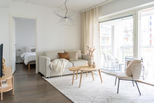 een woonkamer met een bank en een tafel bij Iso aurinkoinen parveke ja hyvät yhteydet in Helsinki