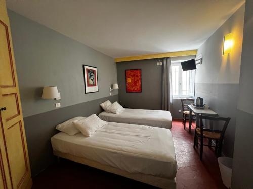 een hotelkamer met 2 bedden en een tafel bij Le Vieux Château in Aiguines
