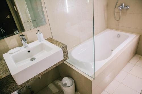 y baño con lavabo, bañera y ducha. en EGO's CONDO-Mactan NewTown Cebu-1BR, en Mactan