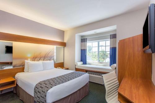 a hotel room with a large bed and a window at Microtel Inn & Suites by Wyndham Port Charlotte Punta Gorda in Port Charlotte