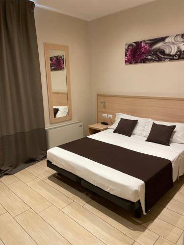 a bedroom with a large bed and a mirror at Hotel San Biagio in Milan