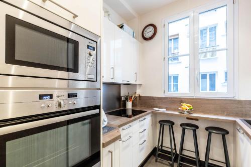 une cuisine avec un micro-ondes et une cuisinière four supérieur dans l'établissement Veeve - Vintage Violet, à Paris