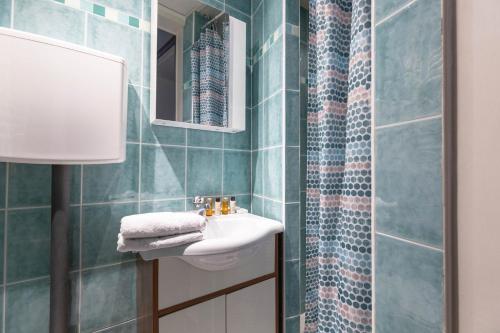 une salle de bain avec un lavabo et un miroir dans l'établissement Veeve - Vintage Violet, à Paris