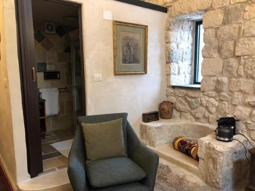 a living room with a chair and a shower at Chateau du Roi in Mi‘ilyā