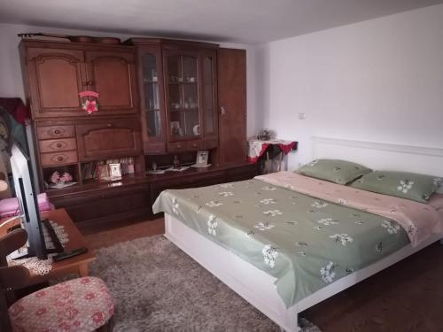 Schlafzimmer mit einem Bett und einem Holzschrank in der Unterkunft Cabanute pitoresti Poiana Largului in Poiana Teiului