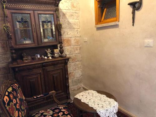 a room with a wooden cabinet and a table at Chateau du Roi in Mi‘ilyā