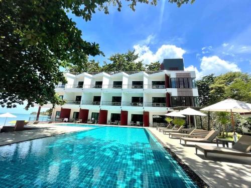 un hotel con piscina frente a un edificio en Prasarnsook Villa Beach Resort, en Sichon