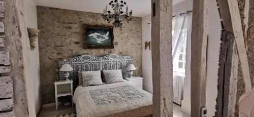 Un dormitorio con una cama blanca y una pintura en la pared en Château de Verdalle, en Verdalle