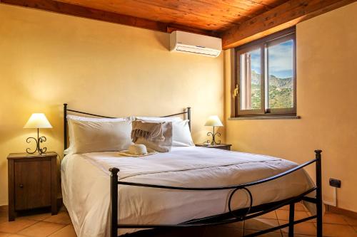 a bedroom with a large bed with a window at Villa Da Campo in Giardini Naxos