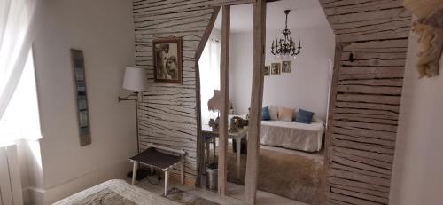 1 dormitorio con 1 cama y pared de madera en Château de Verdalle, en Verdalle