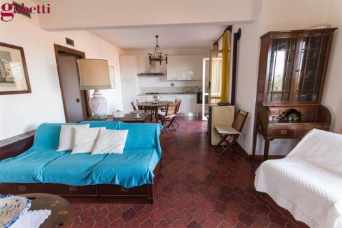 ein Schlafzimmer mit einem blauen Bett und ein Wohnzimmer in der Unterkunft Appartamento Maria Teresa in Porto Santo Stefano