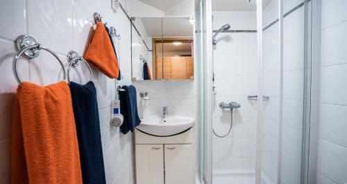 a white bathroom with a shower and a sink at Hotel Kalevala in Kuhmo