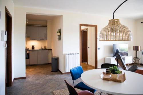 a living room with a table and chairs and a kitchen at Residenza La Corte Visconti - Deluxe flat with pool and patio in Massino Visconti